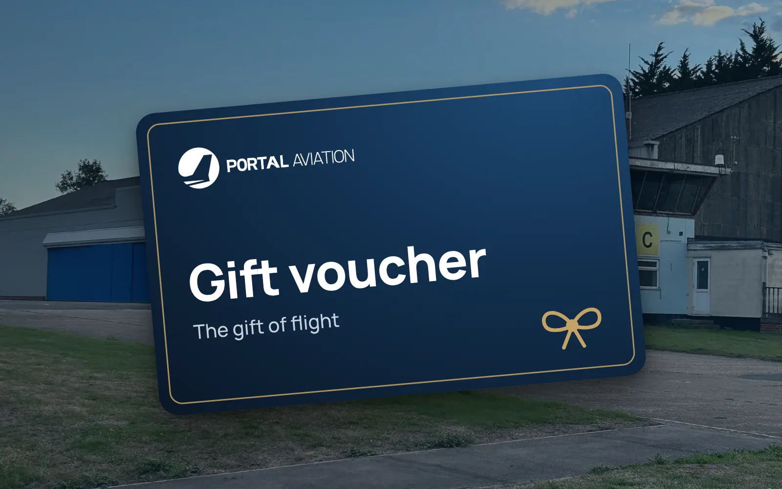 A navy Portal Aviation gift voucher card in front of the hangar and control tower at Rochester Airport